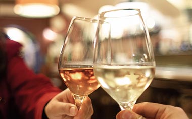 Two people toasting wine glasses